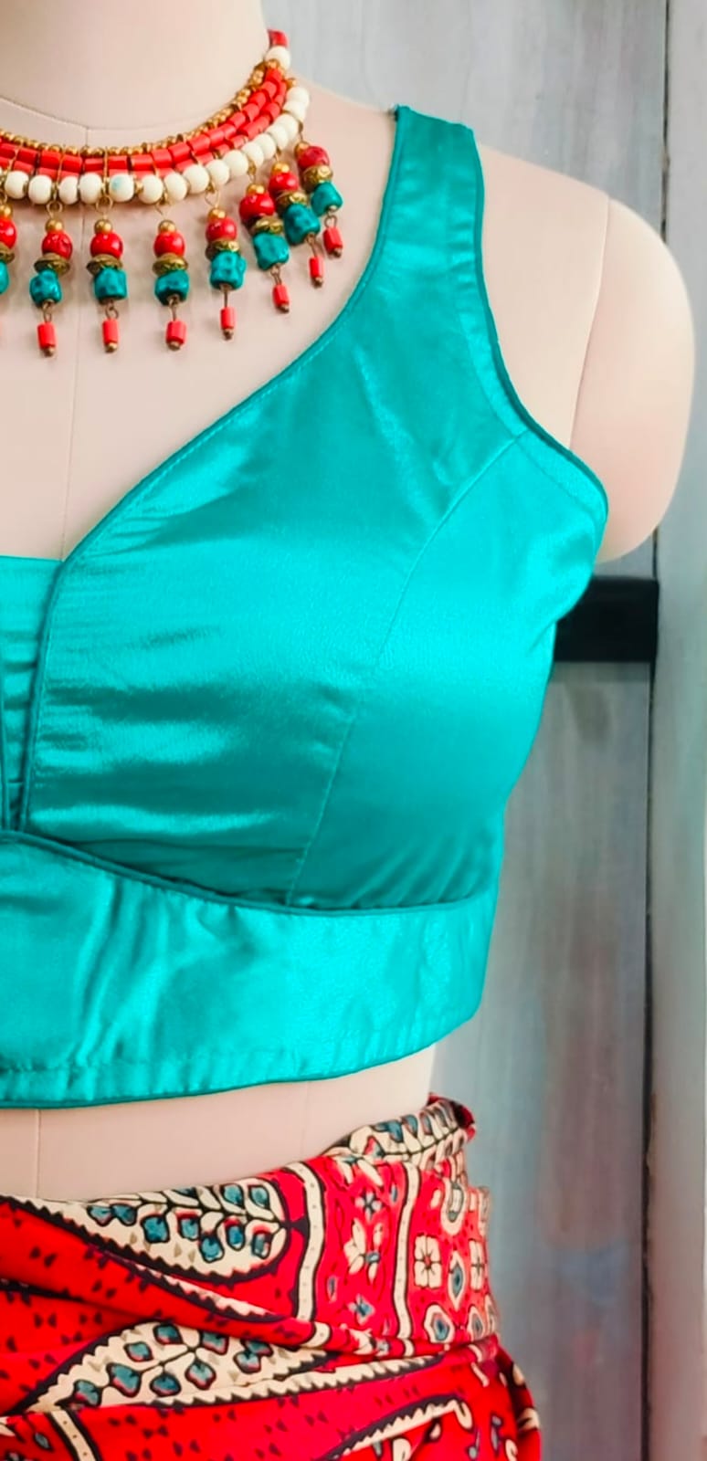 Close-up of turquoise satin blouse bodice